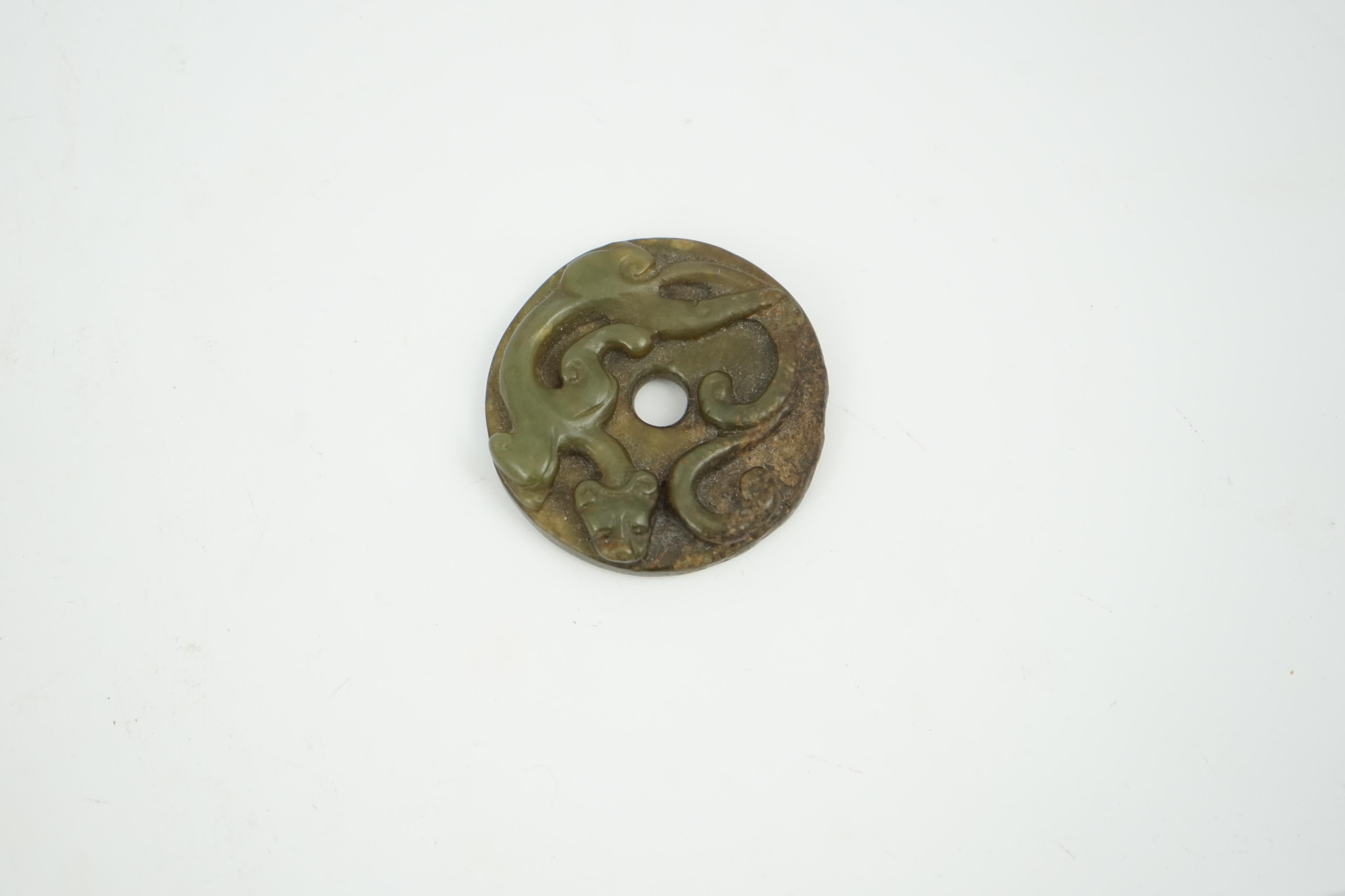 A Chinese green and brown jade bi disc, Yuan/Ming dynasty